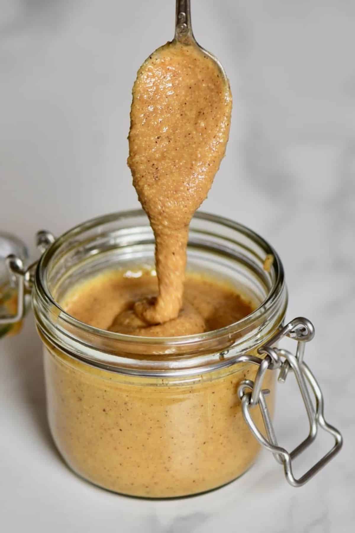 Creamy homemade brazil nut butter in a glass jar.