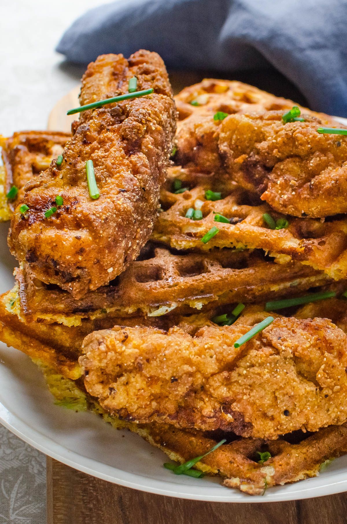 Crispy chicken and waffles in a white bowl.