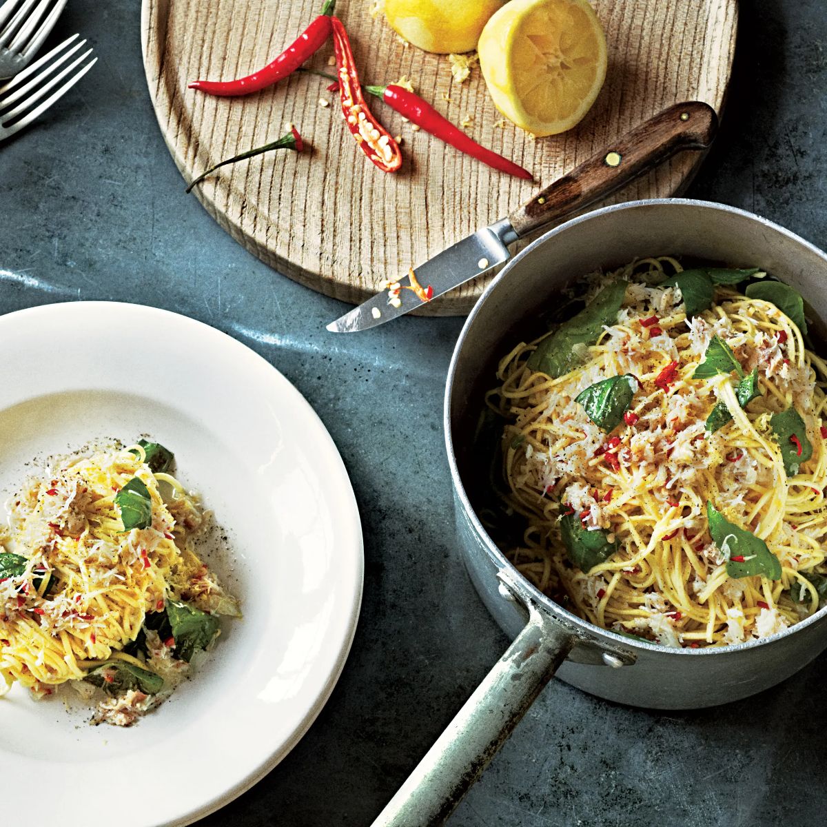 Healthy crab linguine with lemon and chile in a pot and on a white plate.