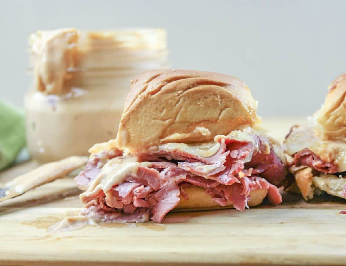 Mouth-watering corned beef sliders on a wooden board.