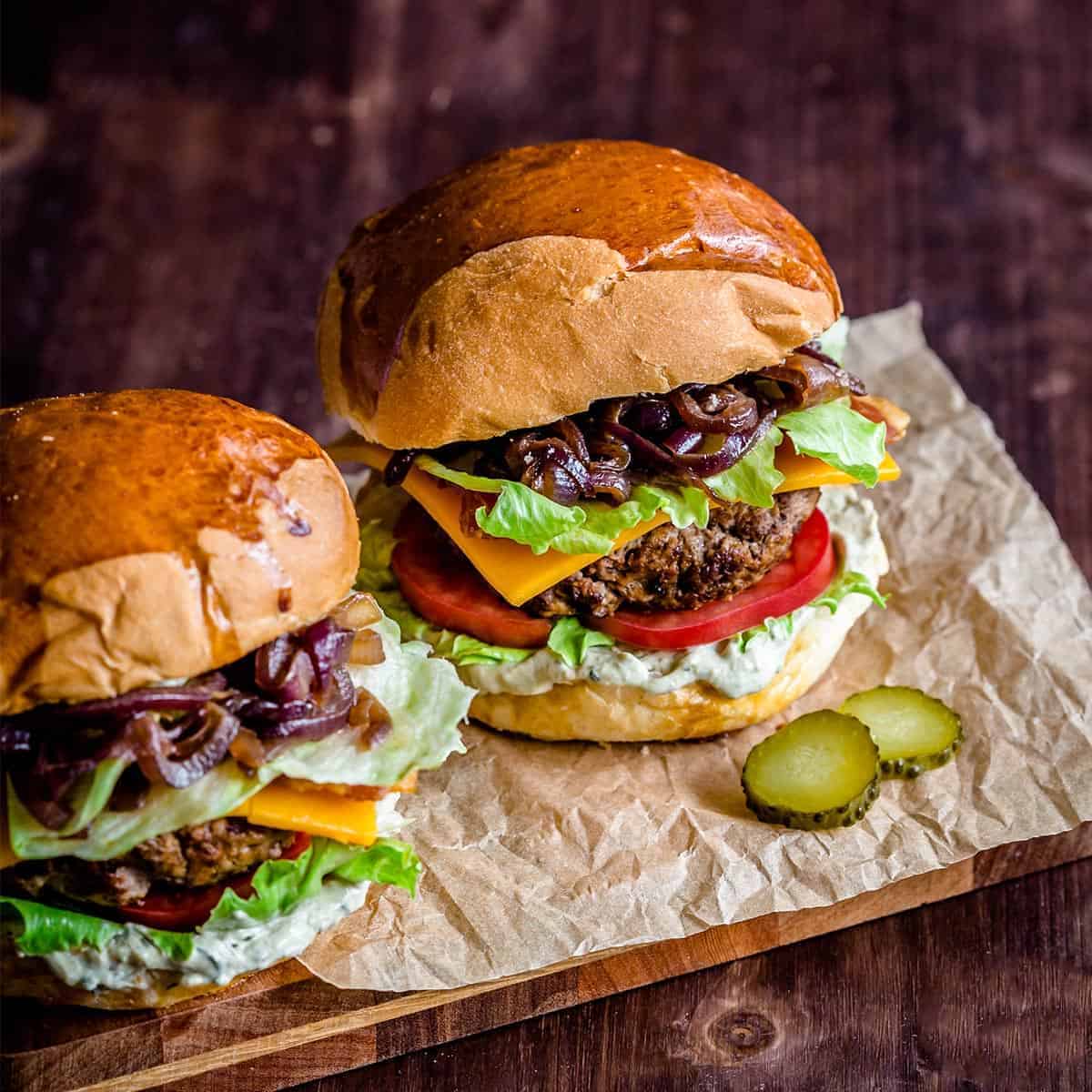 Loaded burgers with bacon, caramelized onions, & avocado crema