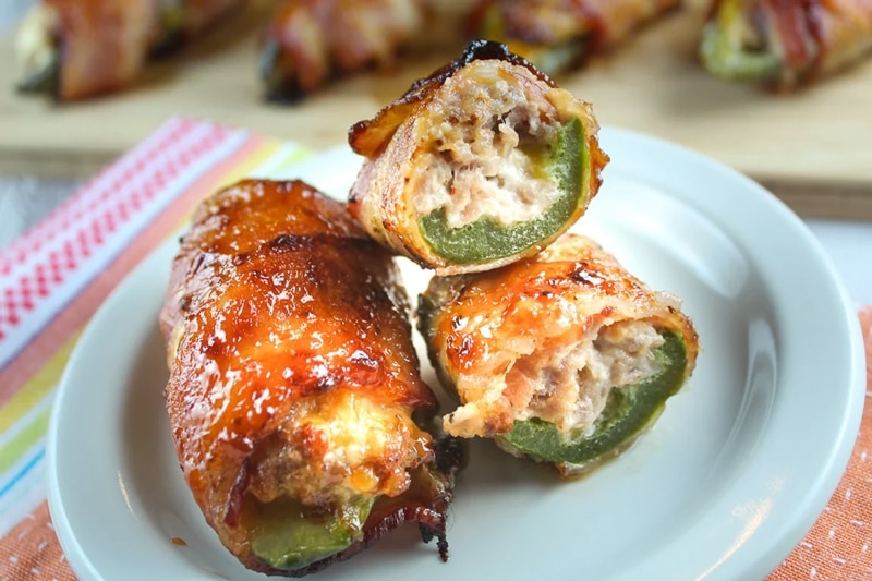 Sausage stuffed jalapenos wrapped in bacon